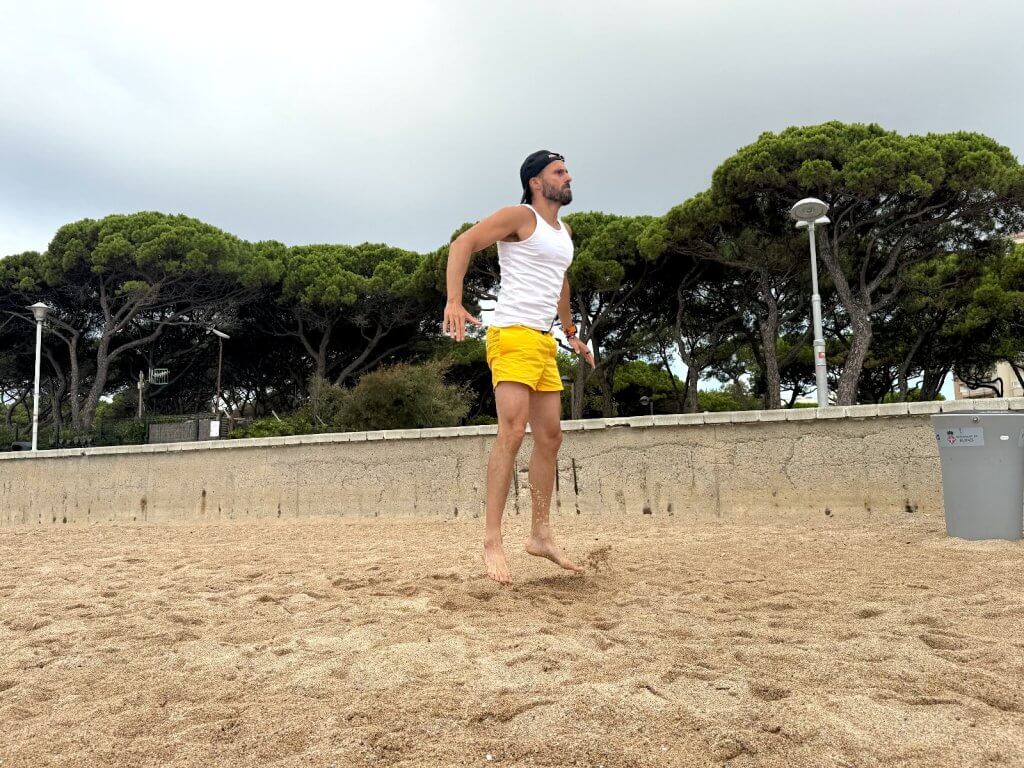 Homme sautant sur la plage