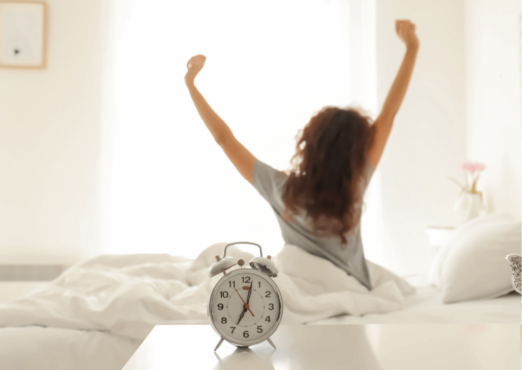 femme qui s'étire au reveil dans son lit